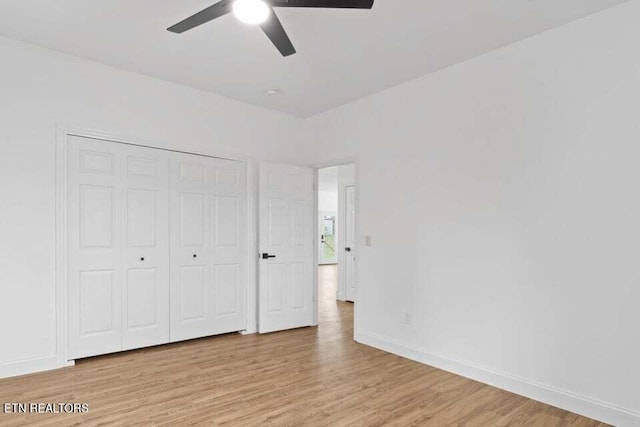 unfurnished bedroom with ceiling fan, a closet, and light wood-type flooring