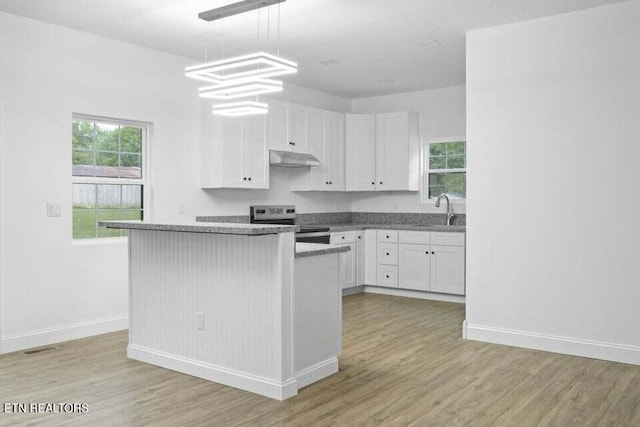 kitchen with light hardwood / wood-style flooring, white cabinetry, hanging light fixtures, and electric stove