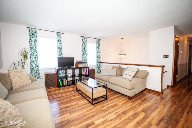 living room with wood-type flooring and a chandelier