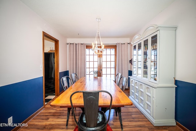 dining room featuring dark hardwood / wood-style floors and an inviting chandelier