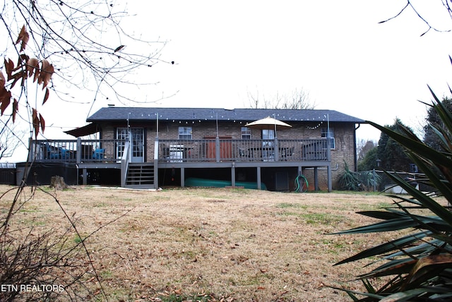 rear view of property featuring a yard and a deck