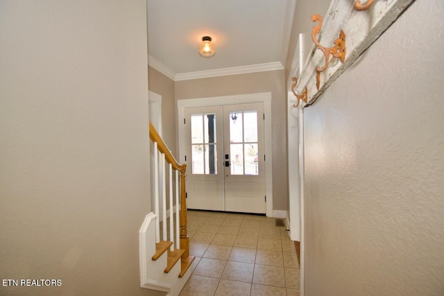 tiled foyer featuring ornamental molding and french doors