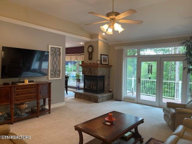 carpeted living room featuring lofted ceiling, a tile fireplace, a ceiling fan, and baseboards