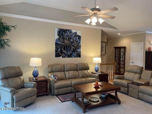 living area with ceiling fan, ornamental molding, vaulted ceiling, and light colored carpet