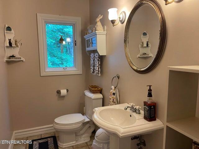 bathroom featuring baseboards and toilet