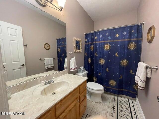 full bathroom featuring toilet, tile patterned floors, a shower with curtain, and vanity