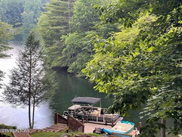 dock area with a water view and a wooded view