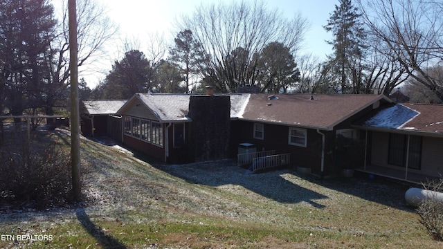 back of house with a sunroom and a yard