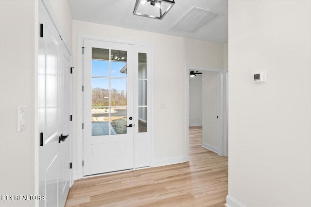 doorway with ceiling fan and light hardwood / wood-style floors