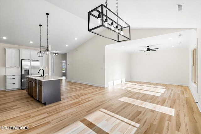 kitchen featuring pendant lighting, a center island with sink, white cabinets, sink, and stainless steel appliances