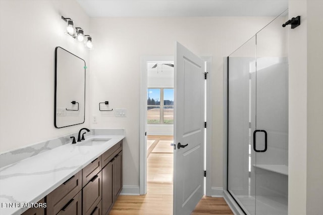 bathroom featuring hardwood / wood-style floors, vanity, and an enclosed shower