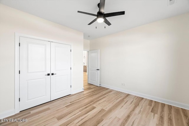 unfurnished bedroom with ceiling fan, light wood-type flooring, and a closet