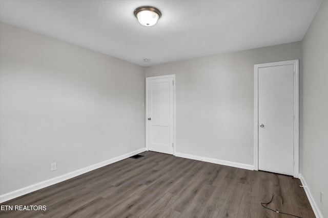 spare room with dark hardwood / wood-style floors