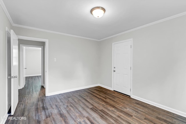 spare room featuring ornamental molding and dark hardwood / wood-style floors