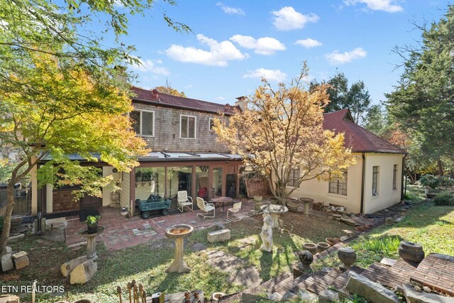 rear view of property with a patio and an outdoor fire pit