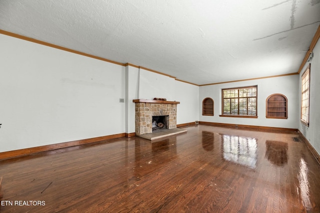 unfurnished living room with ornamental molding, a fireplace, hardwood / wood-style floors, and a textured ceiling