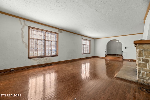 unfurnished living room with hardwood / wood-style flooring, crown molding, and a textured ceiling