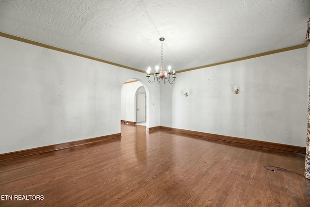 spare room with ornamental molding, wood-type flooring, a chandelier, and a textured ceiling