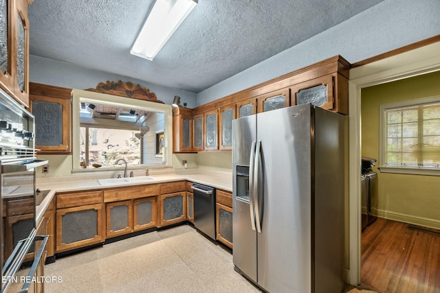 kitchen with appliances with stainless steel finishes, sink, and a textured ceiling