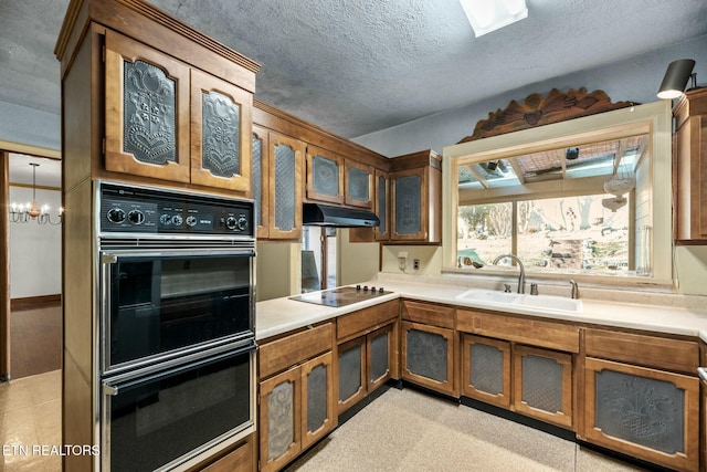 kitchen with sink, a notable chandelier, a textured ceiling, and black appliances