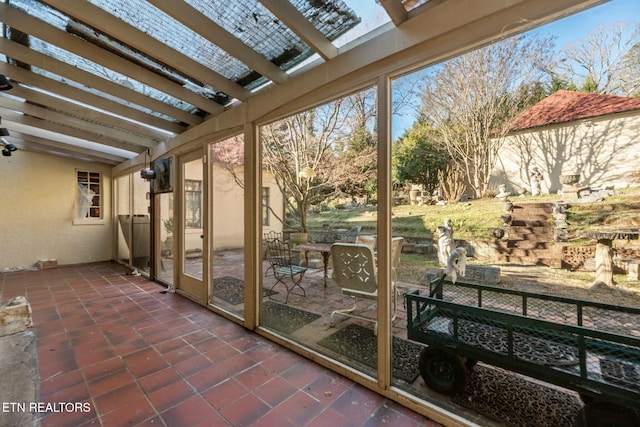 sunroom / solarium featuring beamed ceiling and a skylight