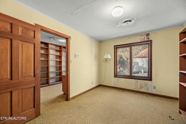 carpeted spare room featuring ornamental molding and a textured ceiling