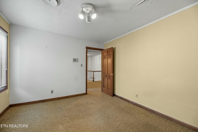 unfurnished room featuring ornamental molding and a textured ceiling