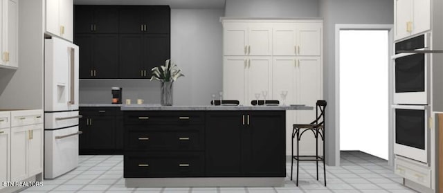 kitchen with white cabinetry, white fridge with ice dispenser, and multiple ovens