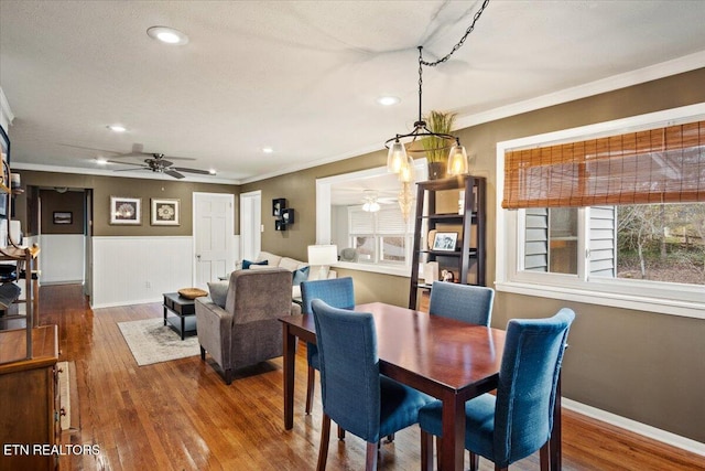 dining space with ceiling fan, wood-type flooring, and crown molding