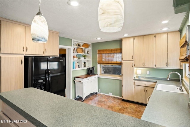 kitchen featuring decorative light fixtures, black fridge, sink, built in features, and light brown cabinets