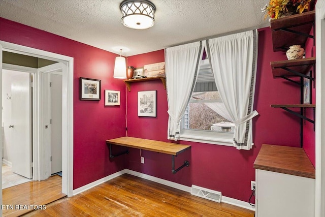 interior space with hardwood / wood-style floors and a textured ceiling