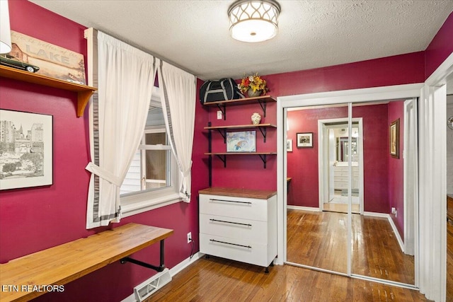 interior space featuring a textured ceiling and hardwood / wood-style flooring