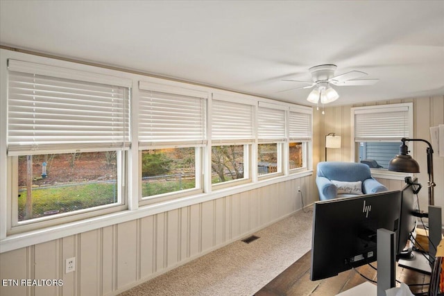 carpeted office space featuring ceiling fan