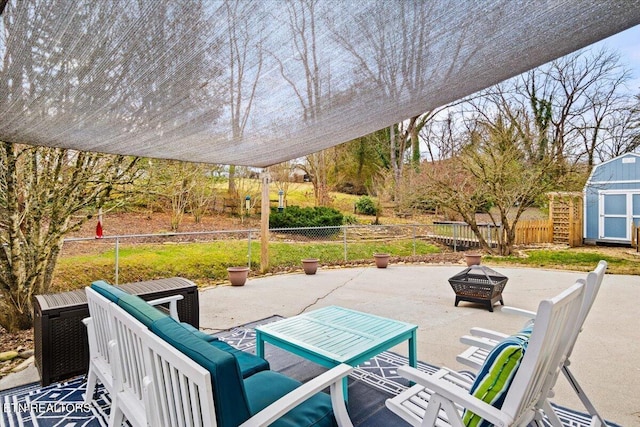 view of patio with a storage unit and a fire pit