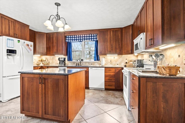 kitchen with pendant lighting, white appliances, a kitchen island, sink, and a notable chandelier