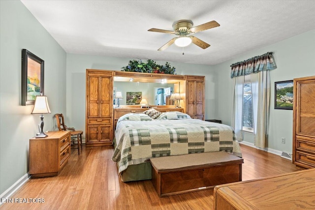 bedroom with ceiling fan, a textured ceiling, and light hardwood / wood-style flooring