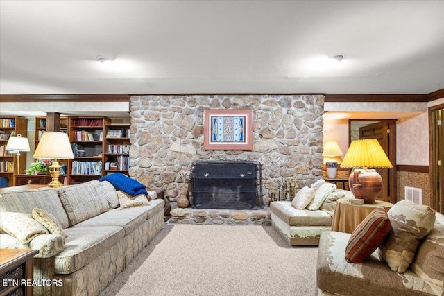 carpeted living room featuring ornamental molding and a fireplace