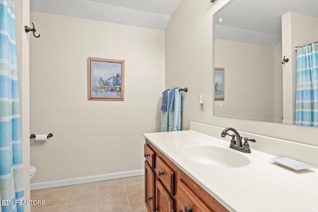 bathroom featuring a textured ceiling, toilet, tile patterned floors, and vanity