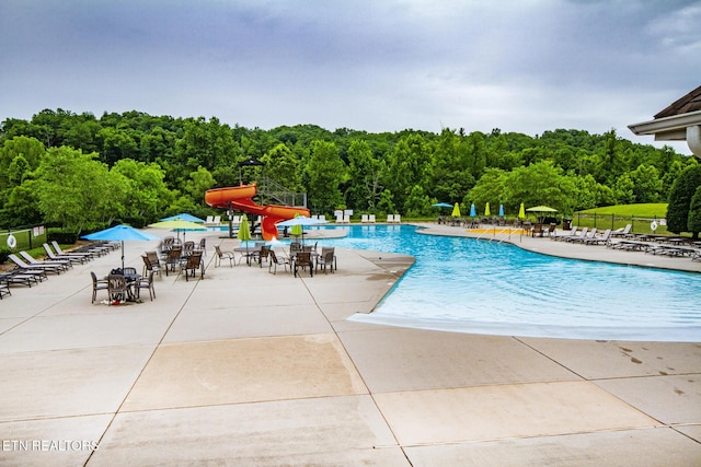 view of pool featuring a patio area and a water slide