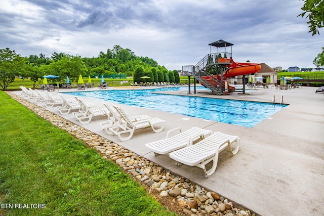 view of pool with a patio area and a water slide