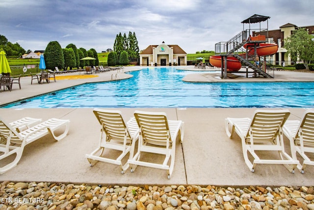 view of pool featuring a patio area and a water slide