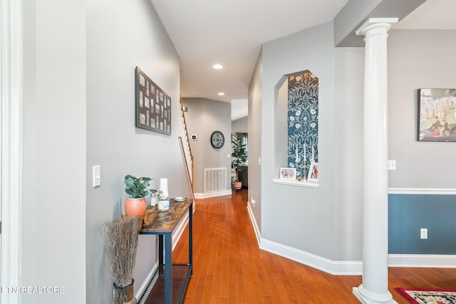 corridor with hardwood / wood-style flooring and decorative columns