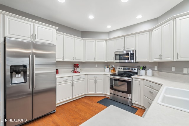 kitchen featuring white cabinetry, light hardwood / wood-style flooring, stainless steel appliances, and sink