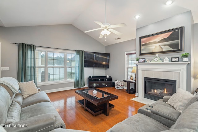 living room featuring plenty of natural light, ceiling fan, a fireplace, and light hardwood / wood-style flooring