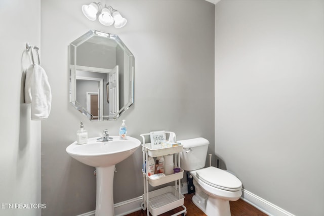 bathroom featuring hardwood / wood-style flooring and toilet