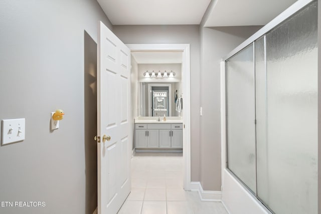 bathroom with tile patterned flooring, vanity, and combined bath / shower with glass door