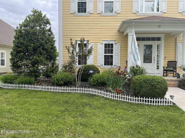 view of exterior entry featuring a lawn