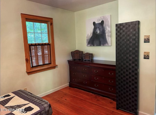 bedroom with dark wood-type flooring