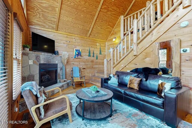 living room with a stone fireplace, lofted ceiling, wooden walls, wood ceiling, and hardwood / wood-style flooring