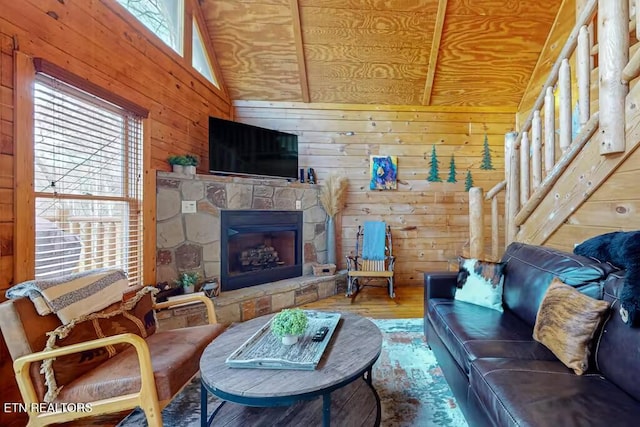 living room with a fireplace, wooden walls, plenty of natural light, and hardwood / wood-style flooring